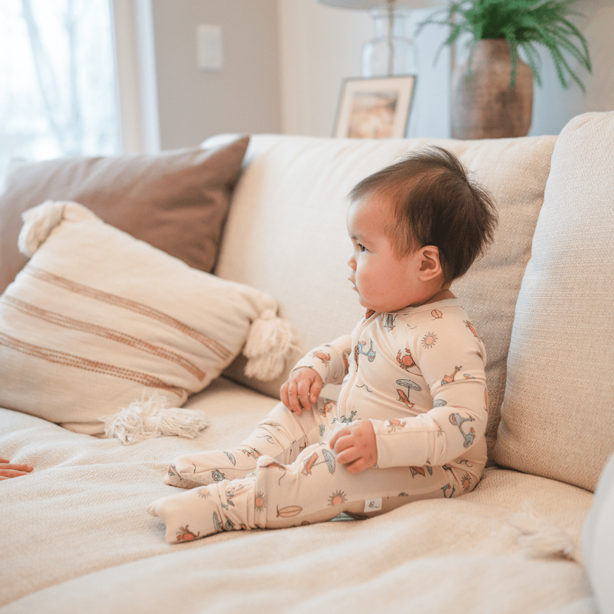 baby sittin gon couch wearing bamboo romper