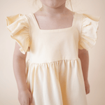 Close-up of the ruffled sleeve and square neckline on the bug + bean kids organic cotton lemonade yellow dress.
