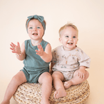 Two babies in matching bug + bean rompers