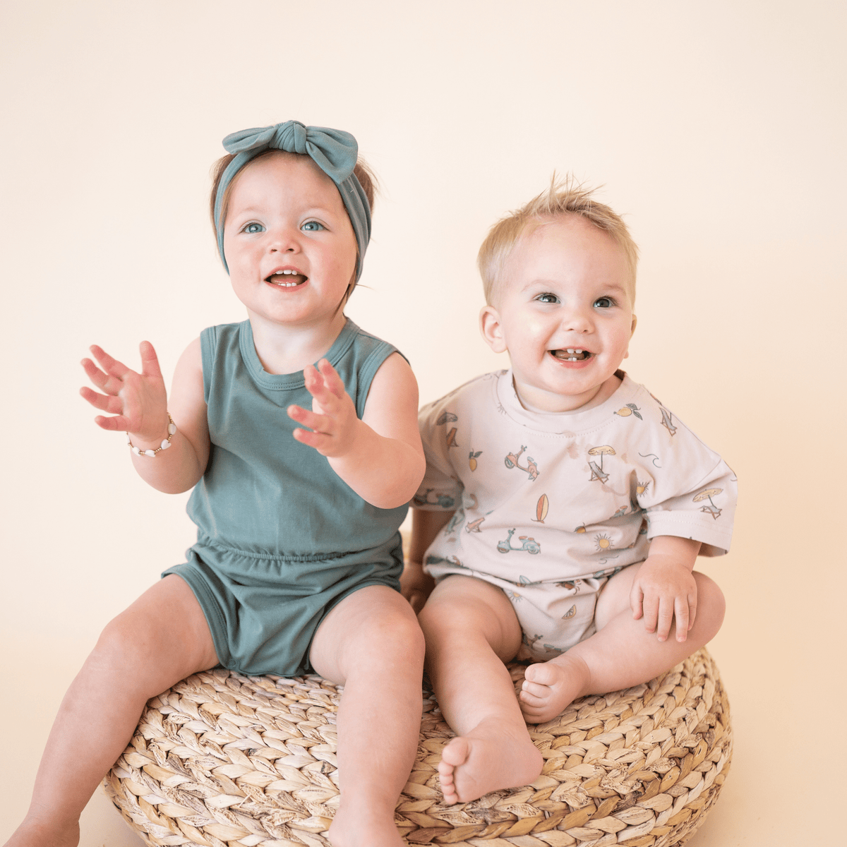 Two babies in matching bug + bean rompers