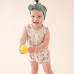 Baby girl in Summer Vibes romper holding lemon.