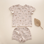 Flat lay of bug + bean kids Summer Vibes organic cotton short set for toddlers, featuring a whimsical beach-themed print on a soft neutral background.