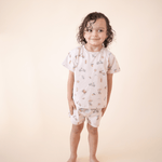 oddler boy smiling in bug + bean kids Summer Vibes organic cotton short set, featuring playful beach-themed illustrations perfect for warm-weather days.